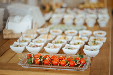 Selective focus shot of tomatoes in a glass plate next to salads
