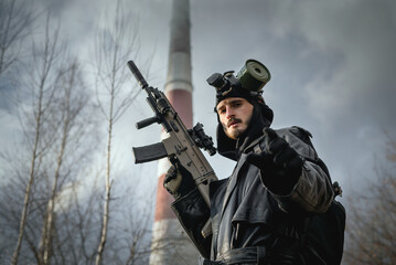 Post apocalypse survivor concept. Man with a rifle in the gas mask.