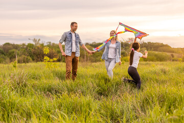 Fototapeta premium Happy family: mother father and child daughter on nature on sunset