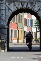Fototapeta na wymiar Cycliste à l'entrée de la vieille ville du Landeron, Suisse