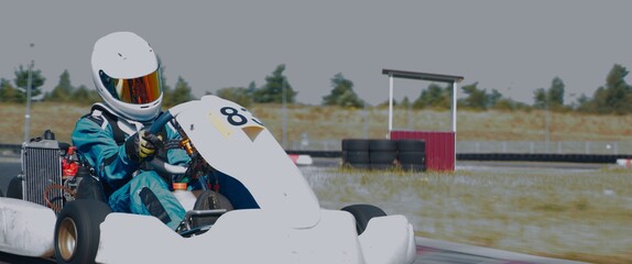 Front view of teenager professional racer driving his go kart on a race track. Shot with 2x...