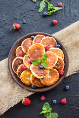 A healthy breakfast of cheese pancakes, berries, and honey. Creative atmospheric decoration