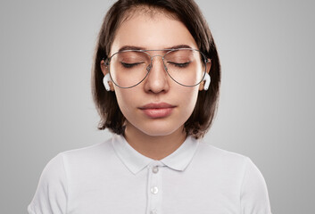 Young woman in earphones listening to music for relaxation