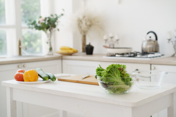 Fresh vegetables and lettuce on white wooden kitchen table