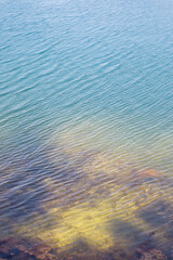 Clear azure water of a lake on a sunny day. Visible shore under water.