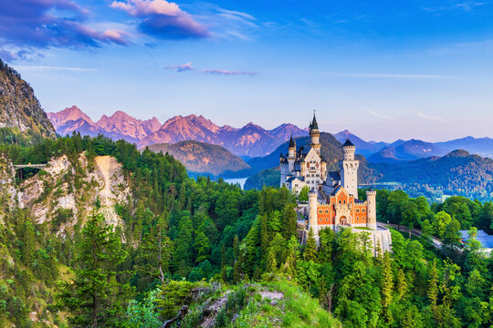Neuschwanstein Castle, Germany. Front view of the castle and Queen Mary's  bridge. The Bavarian Alps in the background.