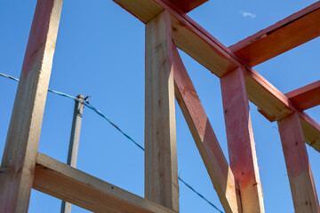 Elements of a frame building under construction. Outdoor construction. Rough pine boards in...