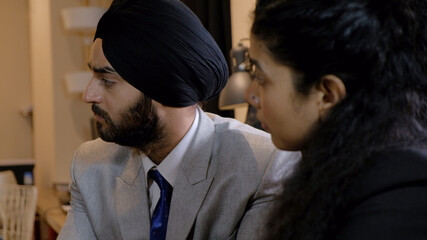 Sikh turbaned boss giving a constructive advice and guidance to his junior who listens attentively