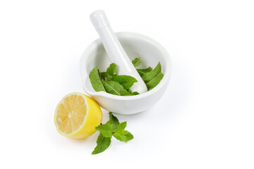 Mint leaves in porcelain kitchen mortar with pestle and lemon