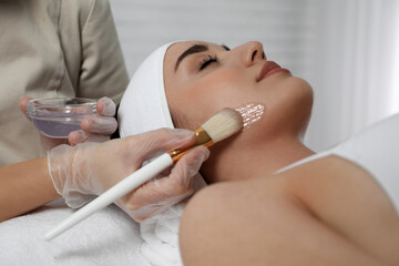 Obraz na płótnie Canvas Young woman during face peeling procedure in salon