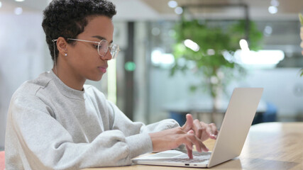 Young African Woman using Laptop in Office 