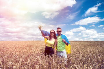 molda happy couple with flag of ukraine in wheat field