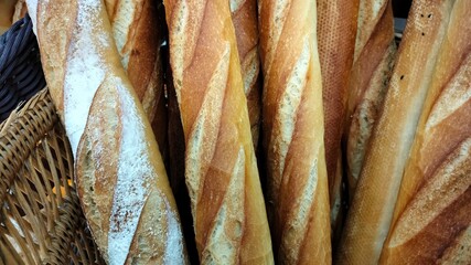 Baguette bread in a basket. Freshly baked French bread in a bakery up close.