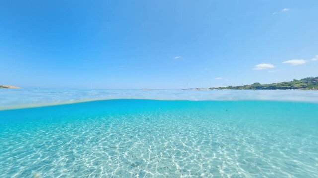 Split-shot, over-under shot. Stunning view of half underwater half sky with a beautiful and turquoise water. Liscia Ruja, Sardinia, Italy.