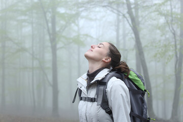 Trekker breathing fresh air in nature a foggy day