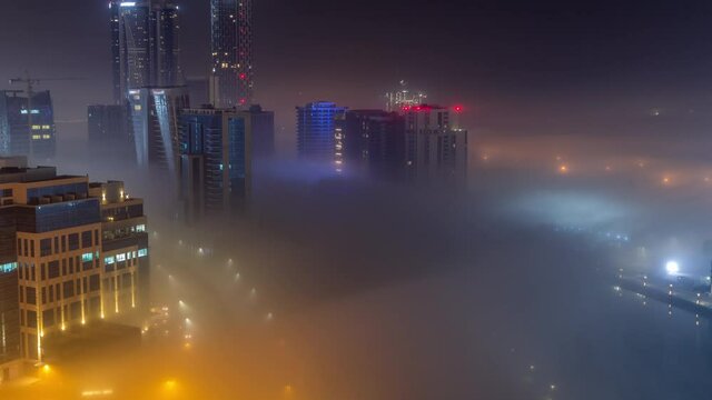Buildings are covered in thick layer of fog in Business Bay night timelapse.