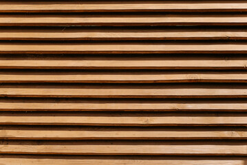 Wooden fence made of horizontal thin boards. Textured brown fence background, wood panels pattern, outdoors