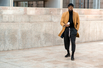 Attractive african man in elegant suit walking in urban city.