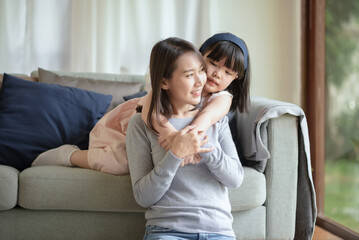 Fototapeta na wymiar Asian mother make love with warm hug her cute daughter at home