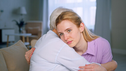 Hugging elderly mother and young daughter on the couch