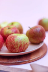 Fresh and ripe apples are lying on a wooden stand in a dessert plate