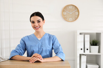 Portrait of receptionist at countertop in hospital - obrazy, fototapety, plakaty