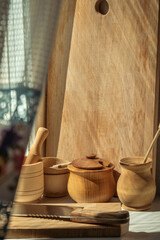 Wooden household dishes and cutting board on the windowsill