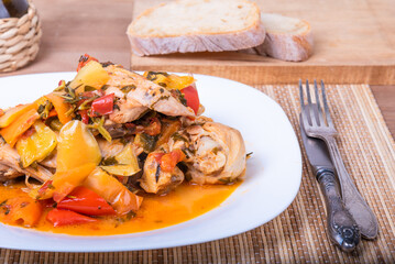 Stewed chicken with bell pepper in a plate, close-up