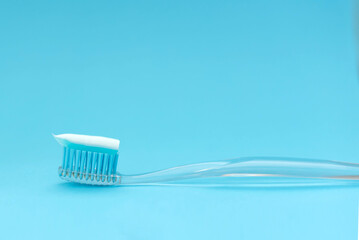 Blue toothbrush with paste on a blue background. Close up. Space fot text.