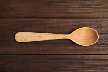 Handmade wooden spoon on rustic table, top view