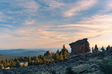 Fototapeta na wymiar Panorama of a rocky valley in sunlight at the top of a mountain. Mountain range against the blue sky at sunset.