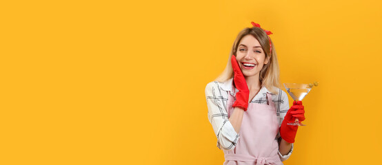 Young housewife with glass of martini on yellow background. Space for text