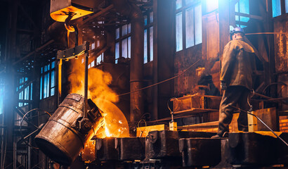 Liquid metal pouring into molds. Metal melting in furnaces in foundry metallurgical plant, heavy...