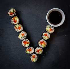Vegan Sushi on a black plate arranged as a V to represent the vegan logo symbol