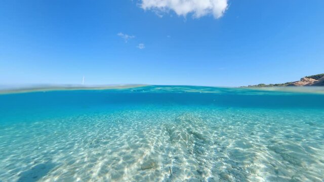 Split-shot, over-under shot. Stunning view of half underwater half sky with a beautiful and turquoise water. Liscia Ruja, Sardinia, Italy.