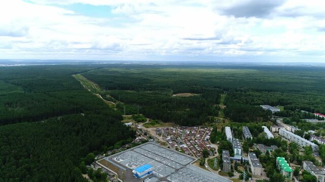 Electricity production substation with contemporary equipment on switchyard between green forest and city aerial view
