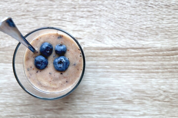 Banana and blueberry vegan nice cream, served on wooden table. Flat lay.