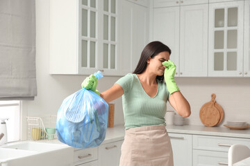 Woman holding full garbage bag at home