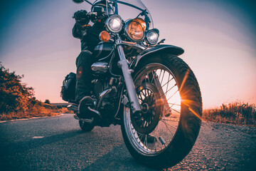 Driver riding motorcycle on an empty road - obrazy, fototapety, plakaty
