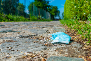 Mask thrown along a road and in nature. Pollution. Slag and plastics. Recycling and environmental...