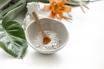 Spa composition with powder face mask and flowers.