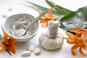 Spa composition with powder face mask and flowers.