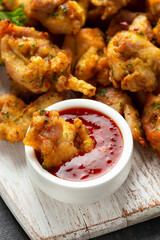 Chicken Pakora dish with sweet chilli sauce on white wooden board