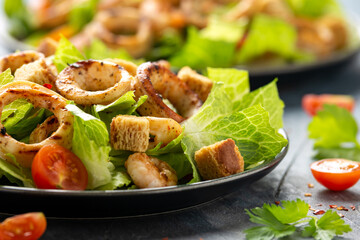 Grilled squid or calamari and prawns salad with garlic croutons and cherry tomatoes