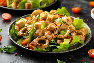 Grilled squid or calamari and shrimp salad with garlic croutons and cherry tomatoes. healthy food.
