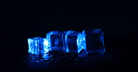 Photo of 5 wet artificial or Blue fake ice cube at Black background
