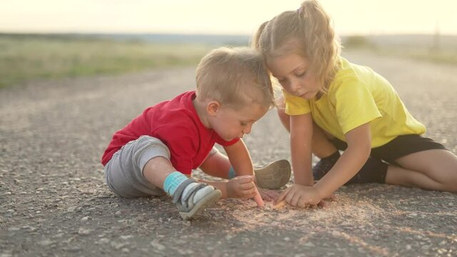 Happy child draw with chalk on asphalt in park. Child play and paint house and sun. Happy family concept Dream of home. Kid dream in park. Concept of kid dream of home. Chalk drawing of sun
