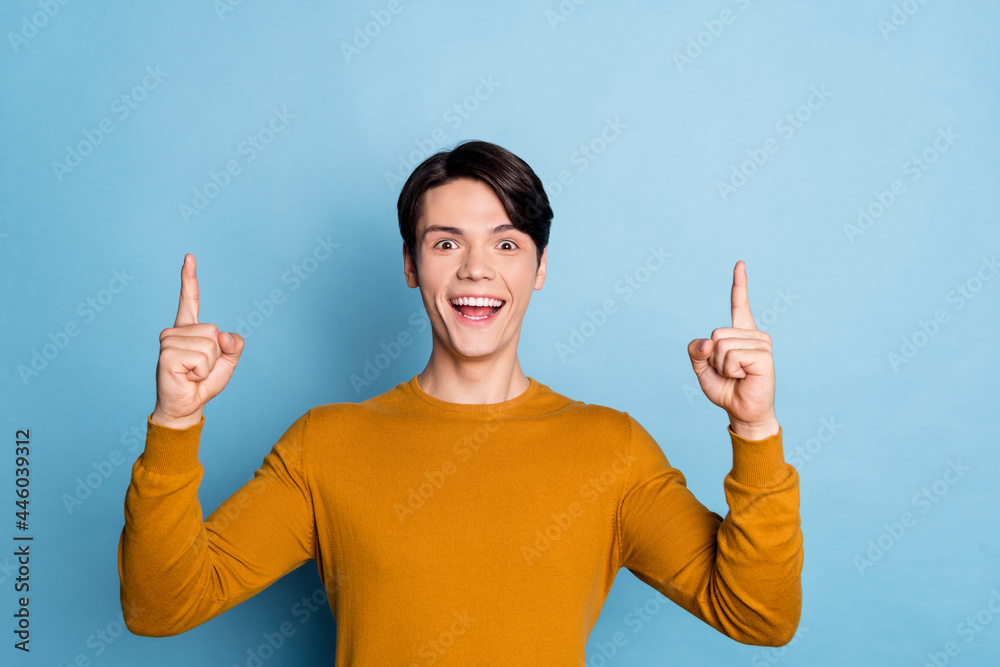 Sticker Photo of young guy happy positive smile indicate fingers up direct way ads decide isolated over blue color background