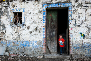 Un niño saliendo de una vieja casa.