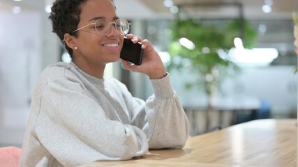 Cheerful Young African Woman Talking on Phone 